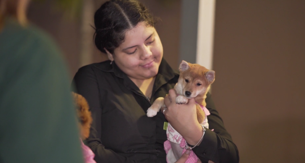 Petland Pembroke Pines picture of a Petland pet counselor holding a cute Petland puppy at WOW Center Block party.