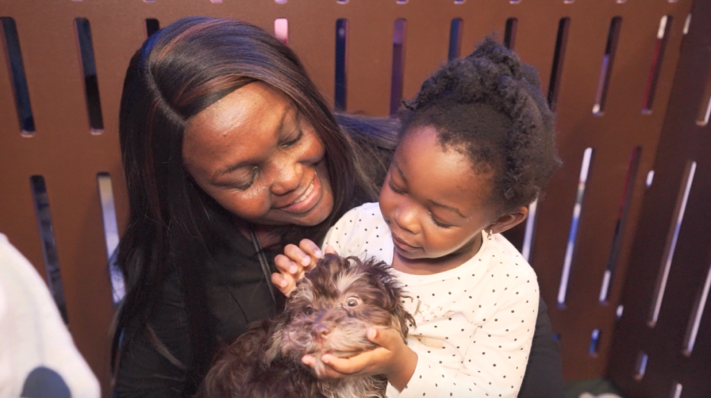 Petland Pembroke Pines picture of a woman and child petting a cute Petland puppy at SnowFest.