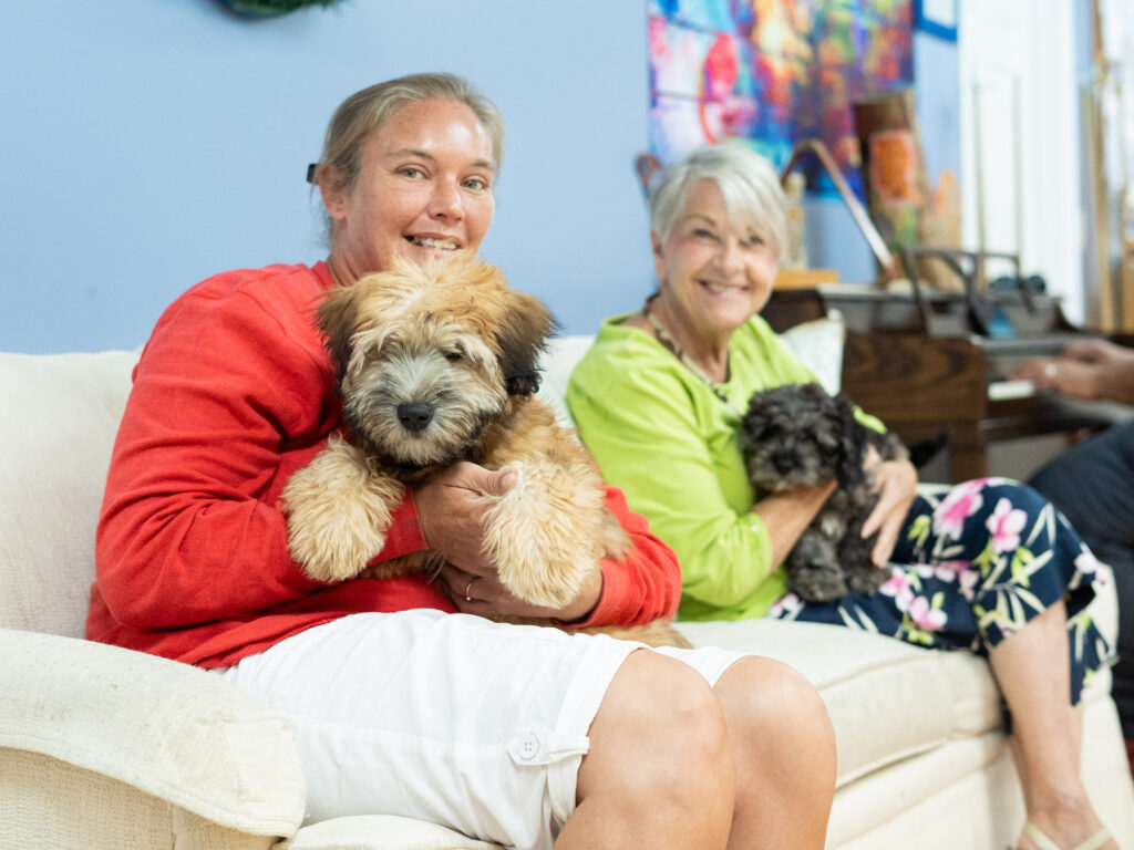 residents of NAMI Center holding cute puppies from Petland Pembroke Pines.