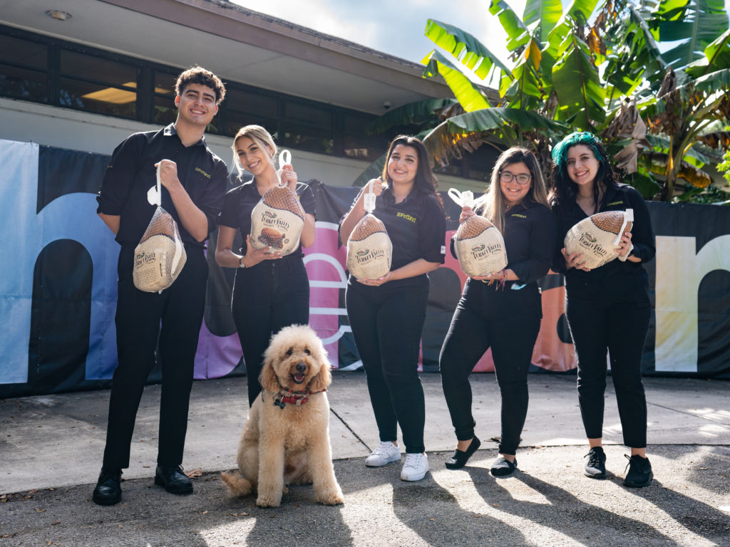A group of volunteers from Petland Pembroke Pines standing with turkeys for a donation event at the WOW Center.