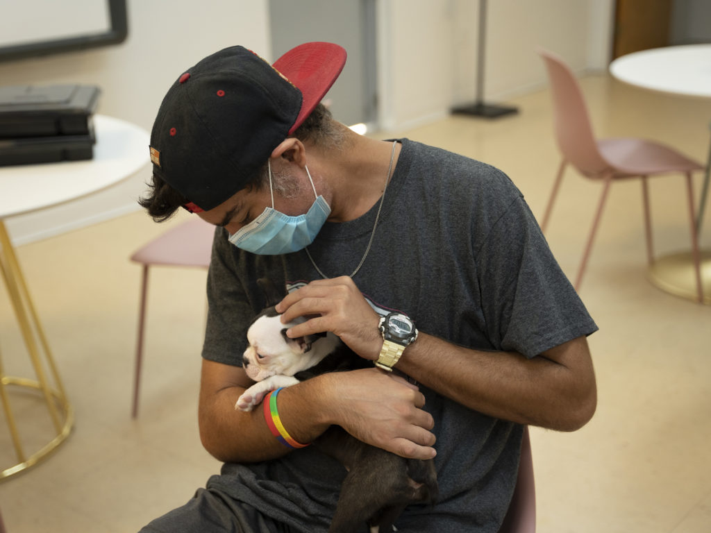 A patient from WOW Center Miami petting and cuddling a cute Petland puppy.